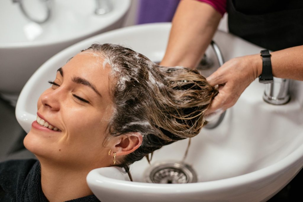 Mujer lavándose el cabello en un salón