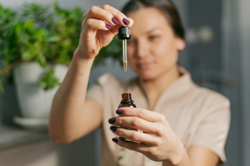 Mujer con un pequeño frasco de aceite escencial