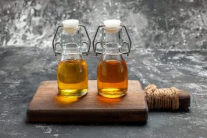 Dos frascos de aceites sobre una tabla de cocina